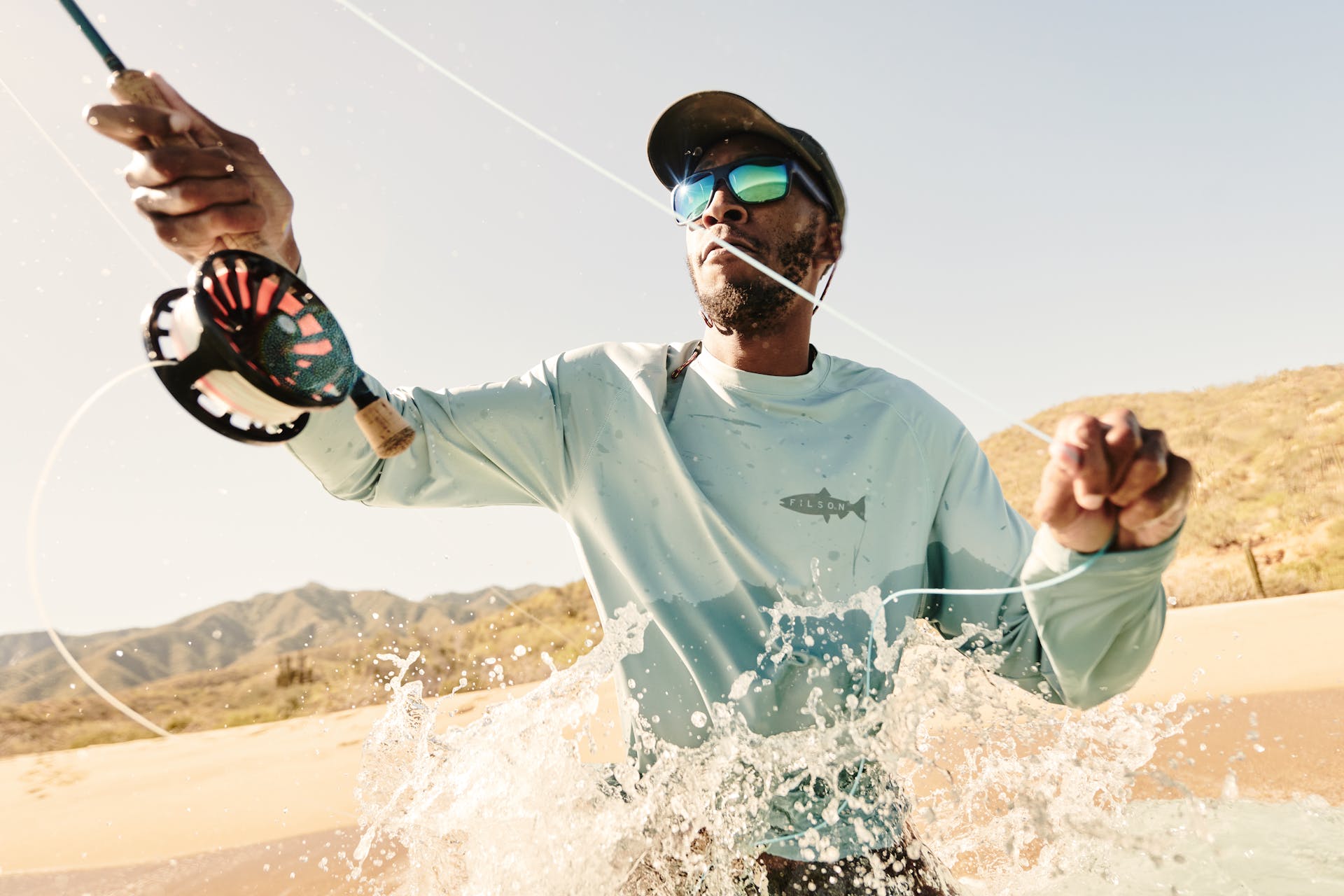 Man fishing in the ocean wearing a Filson Long Sleeve Barrier T-Shirt