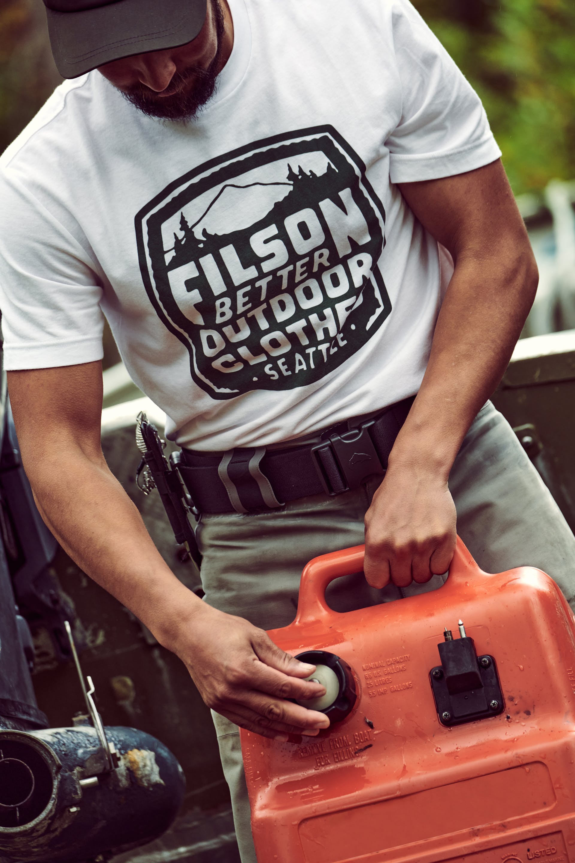 Man holding a gas tank wearing short sleeve Filson Buckshot T-Shirt